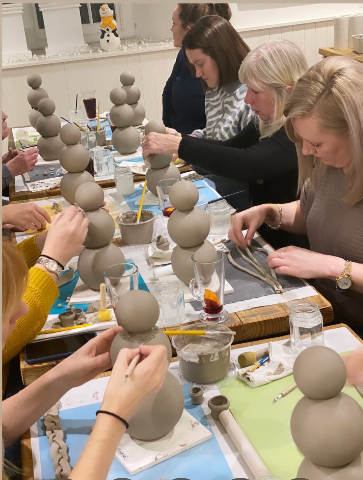 A workshop class making snowmen around the big table